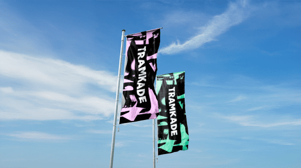 Vlaggen met het logo van Tramkade voor een blauwe lucht